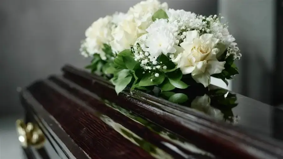 Fleurs blanches déposées sur un cercueil lors d'une cérémonie funèbre