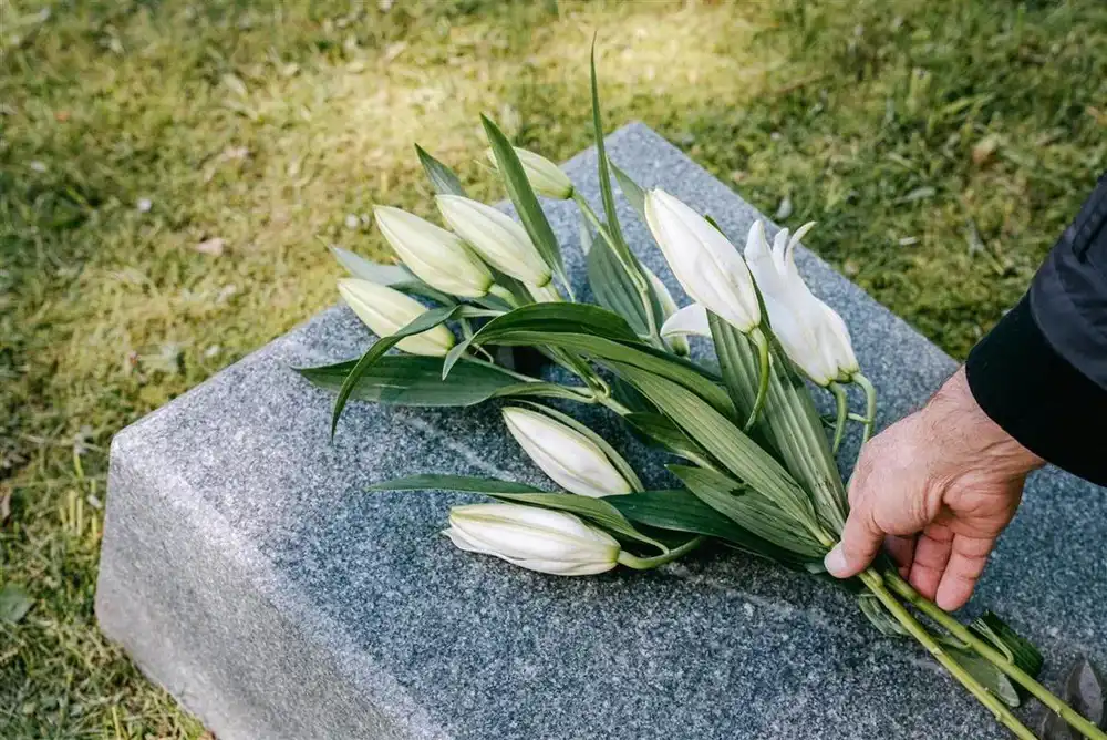 Fleurs blanches déposées sur une sépulture en hommage au défunt